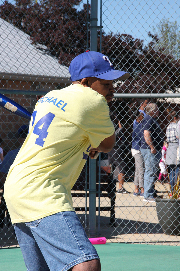 Michael Baker of the Dandy Lions eyes the ball just before he takes a powerful swing - Moody Miracle League